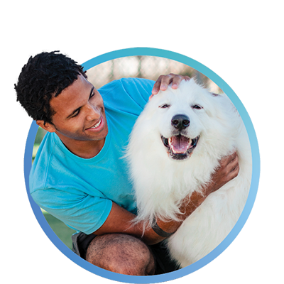 a man petting a white dog