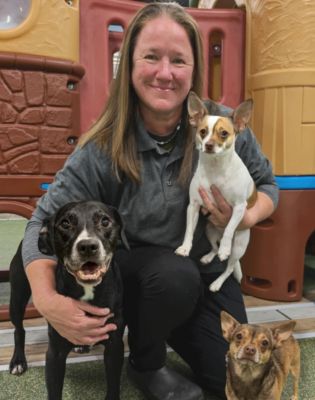 a woman holding two dogs