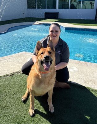 a woman kneeling next to a dog