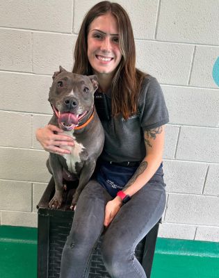 a woman sitting on a crate with a dog