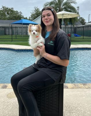 a woman sitting on a chair holding a dog