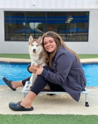 a woman sitting on a chair with a dog