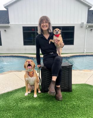 a woman sitting on a chair with two dogs